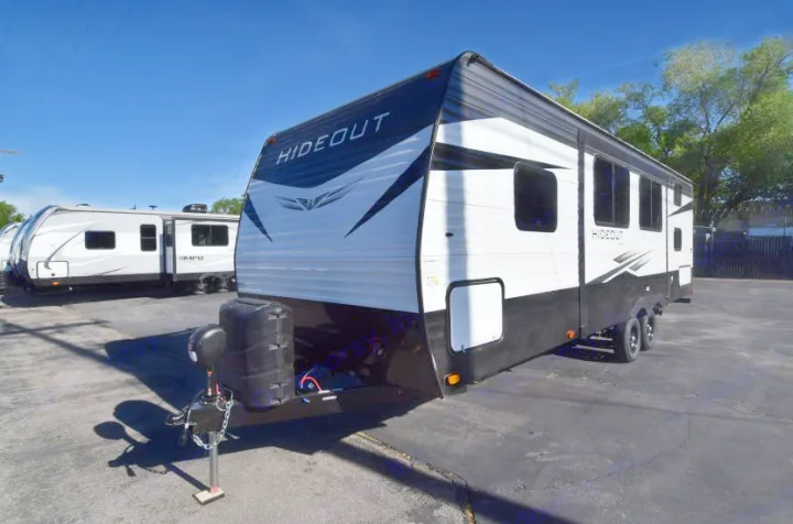 This spacious Hideout travel trailer, perfect for RV rental, is shown on a sunny lot.. Keystone RV Hideout 2021