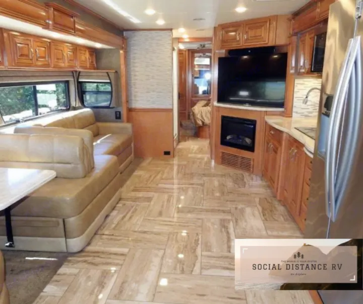 Spacious luxury RV rental interior: living area with sofa, full kitchen, and entertainment center with a fireplace.. Thor Motor Coach Venetian 2017