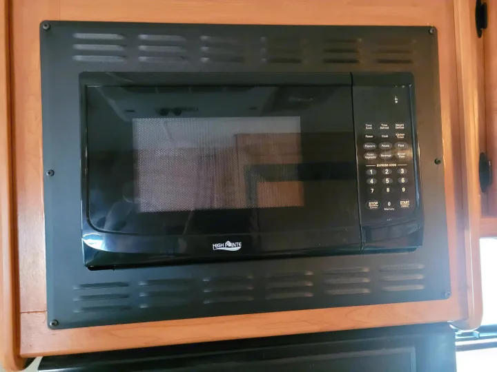 Built-in High Pointe microwave oven in an RV rental kitchen, offering diverse cooking functions via its control panel.. Thor Majestic 2017