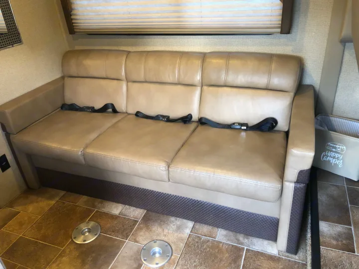 RV rental interior: A tan sofa with three seatbelts provides safe and comfortable travel seating.. Thor Vegas 2017