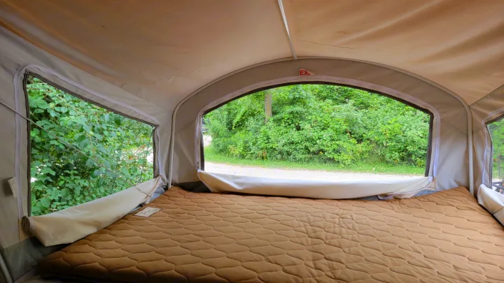 Inside an RV rental pop-up camper bed area. Enjoy lush nature views from this comfortable camping spot.. Forest River Other 2019