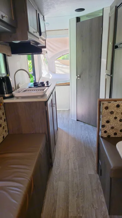 RV rental interior: a clean, compact camper with a kitchen area, dinette seating, and wood-patterned floor.. Forest River Other 2019