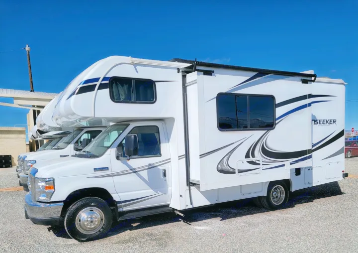 White Forest River Seeker Class C motorhomes, with one slide-out extended, parked for rv rental under a clear sky.. Forest River Sunseeker 2020