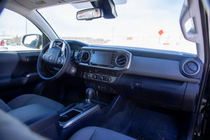 Toyota Tacoma interior: modern dashboard, steering wheel, and infotainment. Ideal for your next RV rental adventure.. Toyota Tacoma 2022
