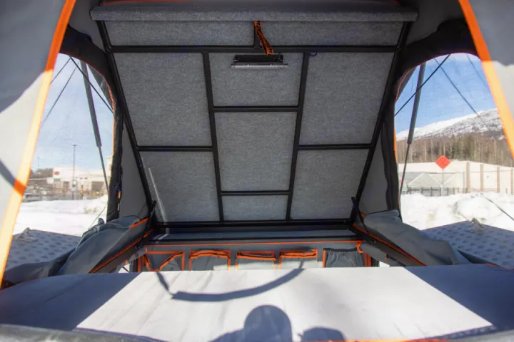 Inside a pop-up rooftop tent, perfect for an RV rental. Features a felt-lined ceiling, integrated light, and organized storage.. Toyota Tacoma 2022