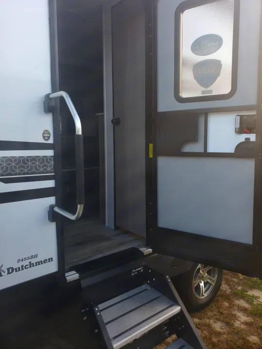 Open entrance of a Dutchmen 2455BH travel trailer RV rental, featuring Solid Steps & interior view.. Coleman 2455bh 2022