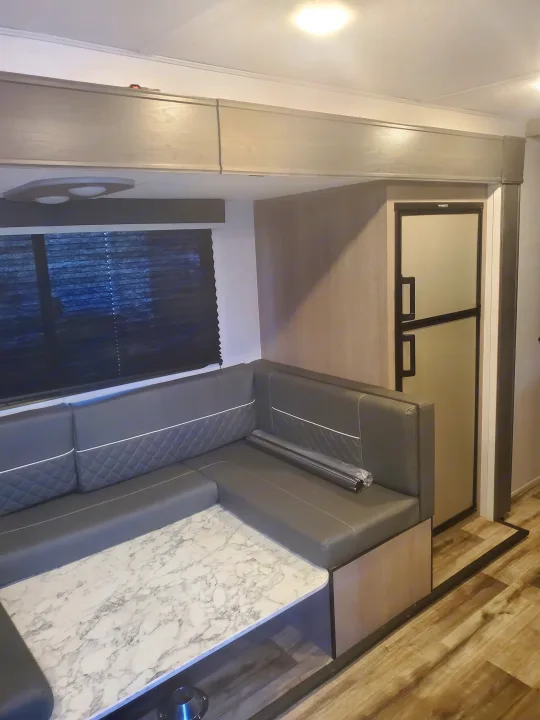 RV rental: Modern gray U-shaped dinette, marble table, overhead cabinets, and Dometic fridge in a spacious living area.. Coleman 2455bh 2022