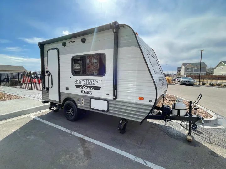 Explore the outdoors! This light gray Sportsmen Classic travel trailer, perfect for your next RV rental, is ready for adventure.. Sportsmen Classic 2022