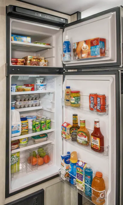 This full and organized RV rental refrigerator, brimming with food and drinks, is ready for your travel adventures.. KZ Sportsmen 2021