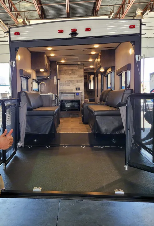 Interior, dining area (fold down beds), 2 recliner chairs, kitchen area, fireplace and ramp with patio. Coleman Lantern 251TQ 2021
