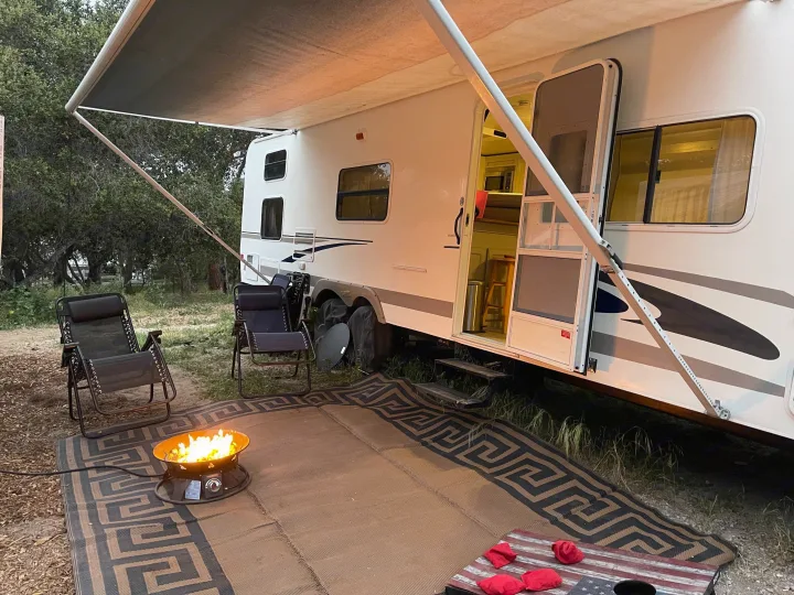 Enjoying an RV rental setup with a cozy fire pit, outdoor rug, camping chairs, and cornhole game.. R-Vision Trail-Lite Trail-Cruiser 2004