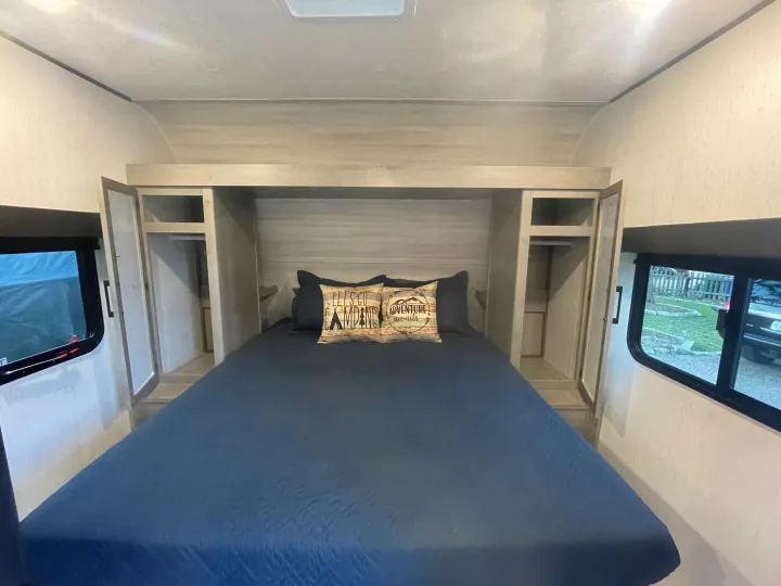 Comfortable RV rental bedroom with built-in storage and cozy bedding, perfect for travel accommodations.. Dutchman Kodiak SE 2022