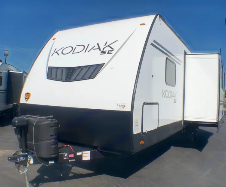 White Kodiak SE travel trailer, ideal for an RV rental. Features a front hitch and extended slide-out.. Dutchman Kodiak SE 2022