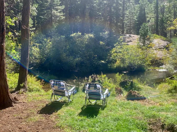 Find peace with your RV rental: Two chairs beside a clear stream in a sunlit forest.. Pleasure Way Lexor 2017