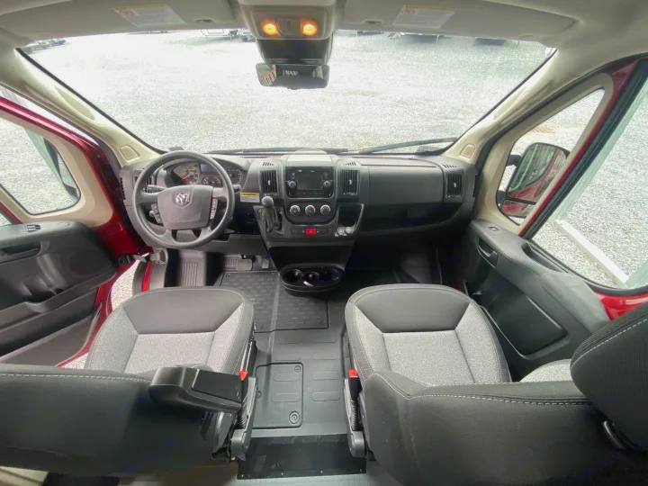 View from inside an RV rental van, featuring its spacious front cabin, dashboard, and comfortable driver and passenger seats.. Winnebago Solis 2022