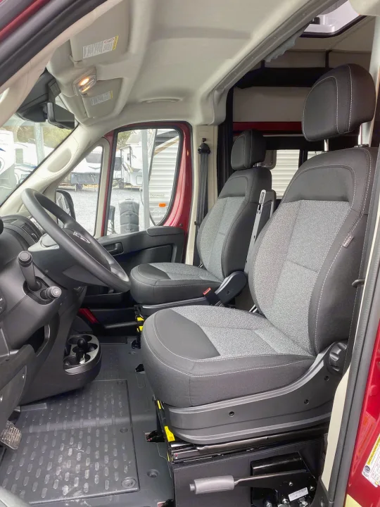 RV rental: Bright, clean van interior featuring front driver and passenger seats, steering wheel, and durable floor mat.. Winnebago Solis 2022