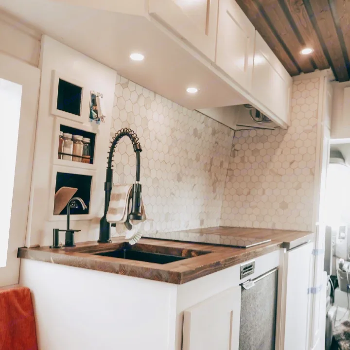 Kitchen equipped with faucet, filtered water tap, soap dispenser, induction stove, refrigerator, spice rack, and utensil storage.. Mercedes-Benz Sprinter 170 2013