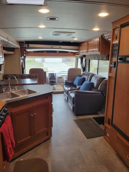 Spacious RV rental interior featuring kitchen, cozy living space, and front cab view. Ideal for road trips.. Winnebago Vista 2018