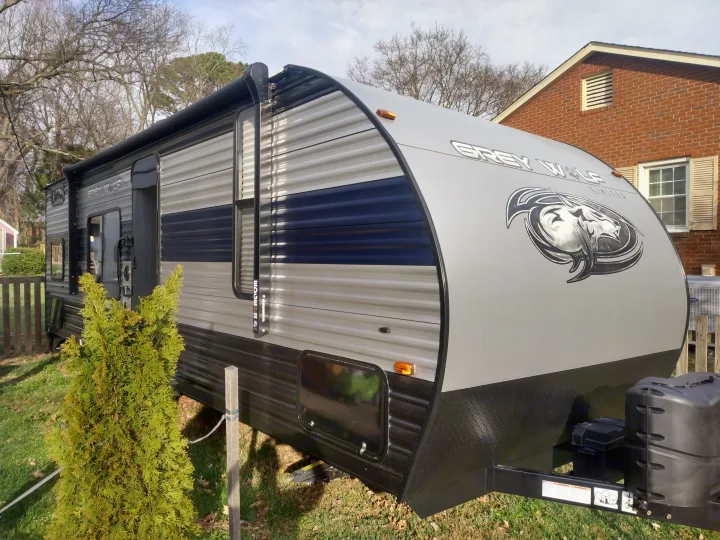A sleek Grey Wolf travel trailer, an ideal RV rental, parked outdoors on a sunny day.. Forest River Cherokee Grey Wolf Special Edition 2021