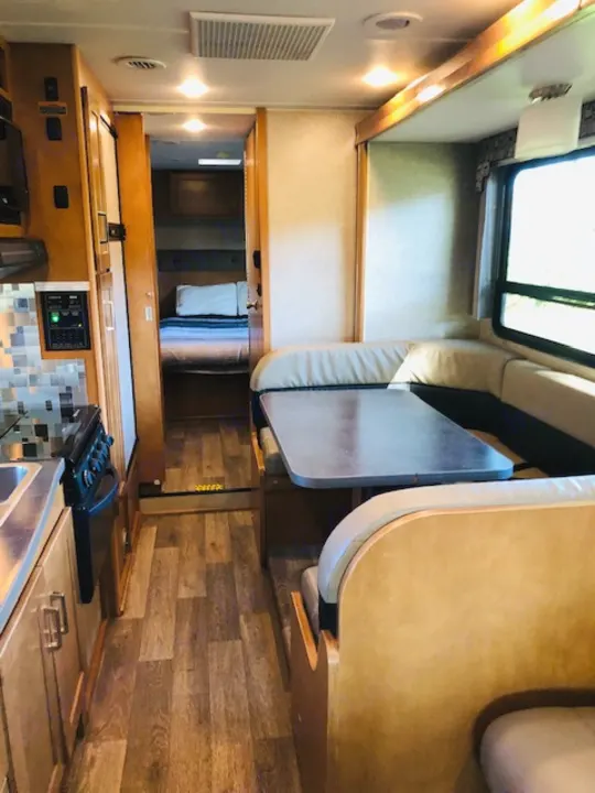 Spacious RV rental interior featuring a kitchen, dining area, and cozy bedroom. Perfect for your next adventure!. Winnebago Minnie Winnie 2019