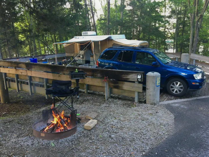 Enjoying a relaxing evening at campsite 43! This pop-up RV rental is set up on a deck with a warm campfire.. Coleman Destiny Royale 1992