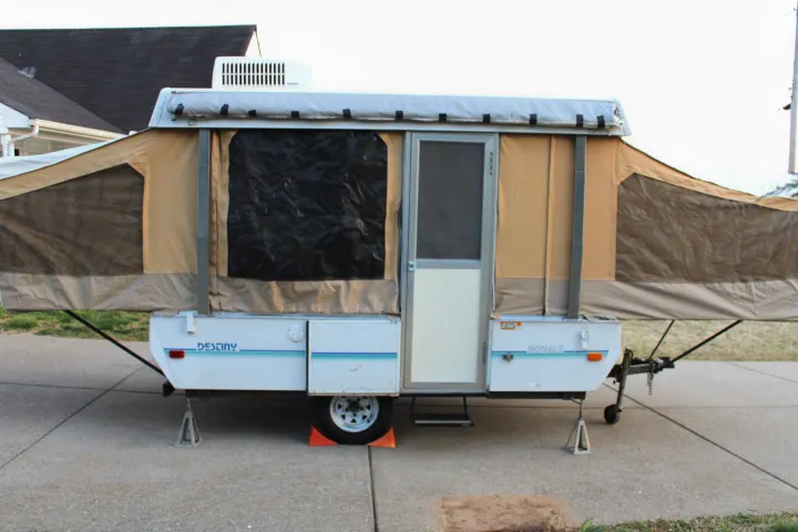 This pop-up RV rental is fully set up on a driveway, ready for your next outdoor adventure.. Coleman Destiny Royale 1992