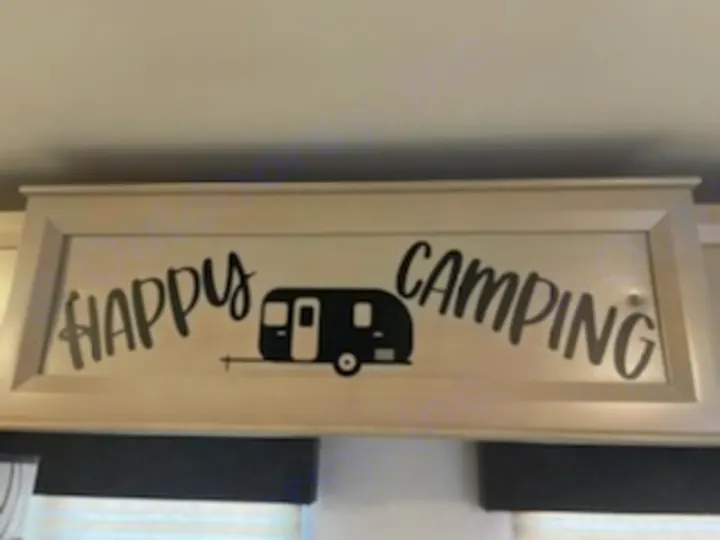 Decorative "HAPPY CAMPING" sign featuring an RV silhouette, evoking fun travel. Great for your next RV rental adventure!. Forest River Tracer 2022