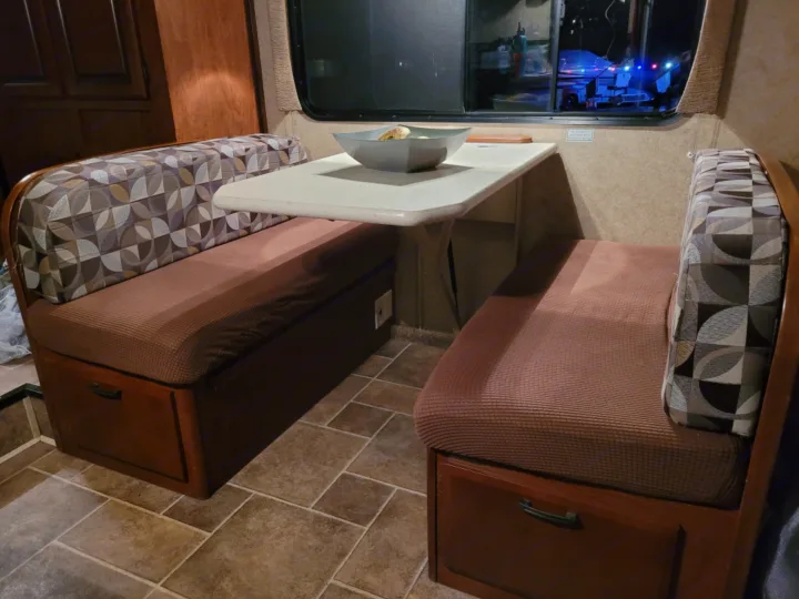 Cozy RV rental dinette with patterned cushions, storage benches, and a central table, ready for meals or relaxation.. Forest River Sunseeker 2013