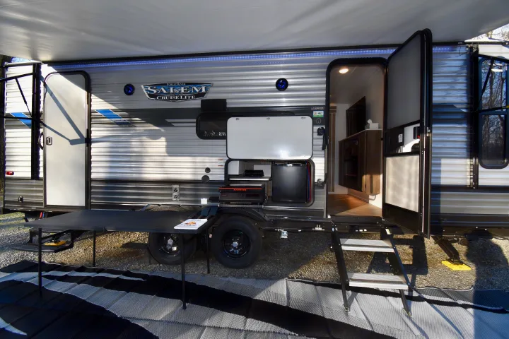 This RV rental features an outdoor kitchen with a griddle, mini-fridge, and extended awning, perfect for camping trips.. Forest River Other 2022