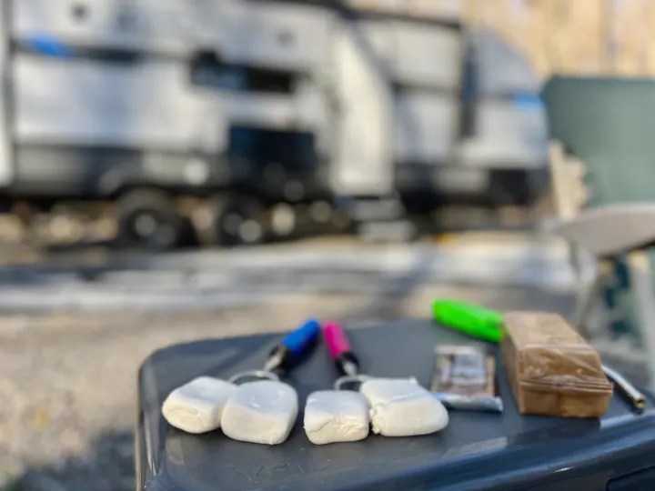 Marshmallow keychains & camping gear on a Yeti cooler, with a blurry RV rental in the background. Ready for adventure!. Forest River Other 2022