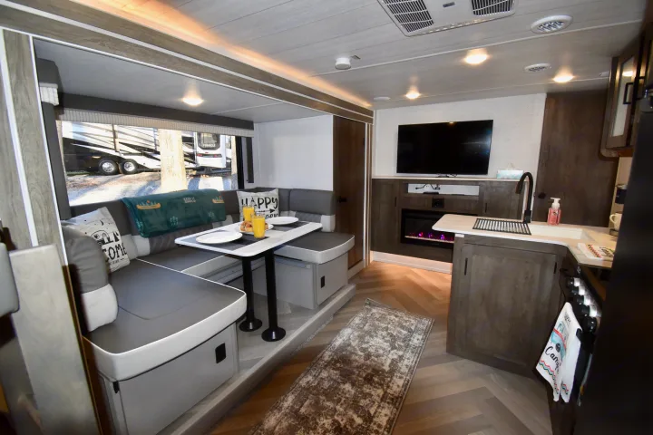 Inside an RV rental: a modern living space with dinette, kitchen counter, TV, and fireplace. Enjoy home comforts on the road.. Forest River Other 2022
