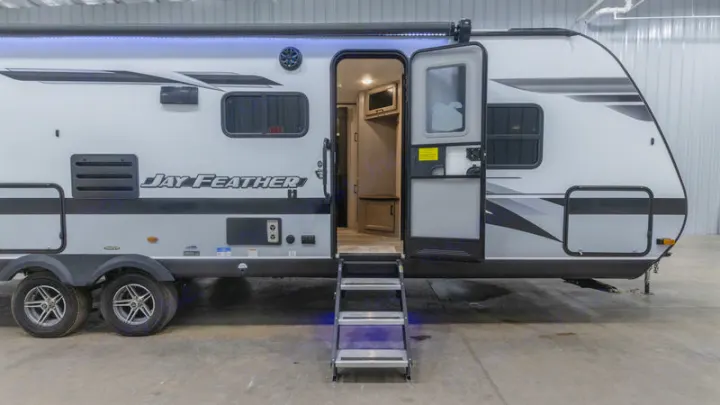 A sleek white & grey travel trailer, door open with steps down, showing the interior. Perfect for an RV rental!. Jayco Jay Feather 2022
