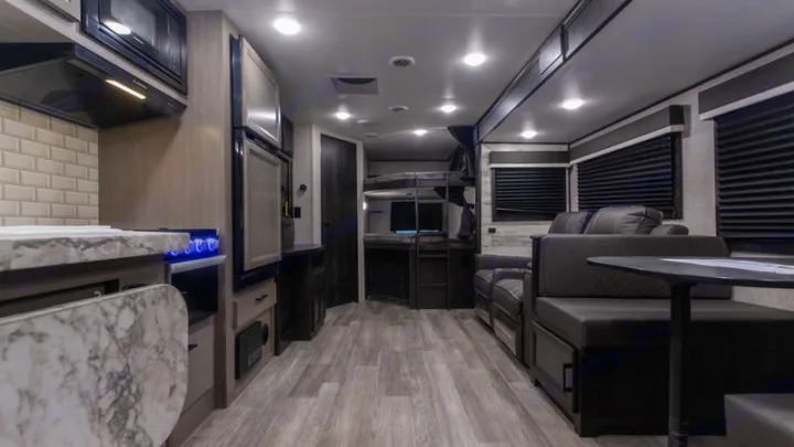 Spacious rv rental interior featuring a modern kitchen, comfortable living area, and bunk beds, ideal for families.. Jayco Jay Feather 2022