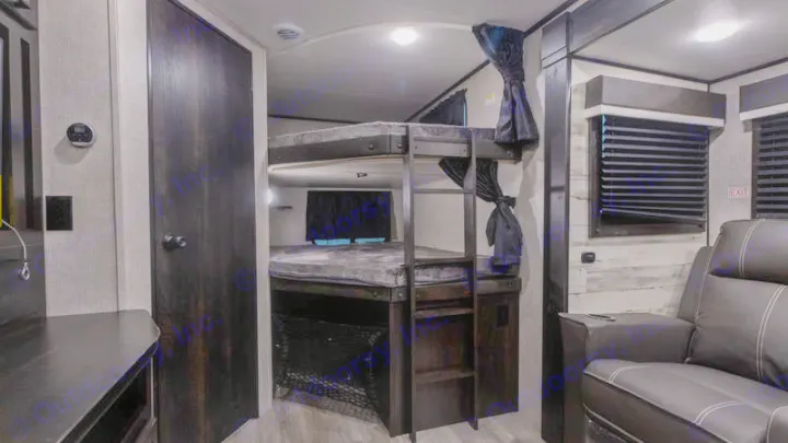 RV rental interior showcasing practical bunk beds, a comfy recliner, and compact living space. Ideal for family travel.. Jayco Jay Feather 2022
