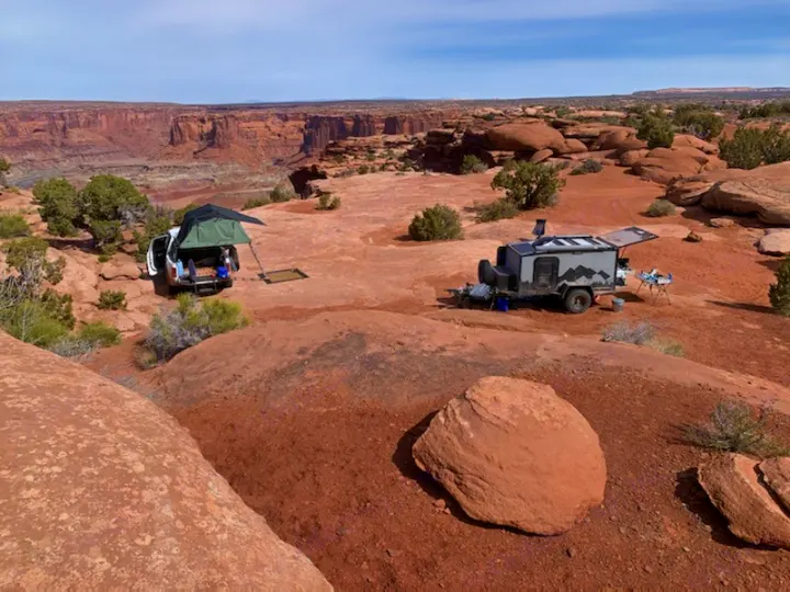 Epic desert camping with an RV rental: a truck with a rooftop tent and an overland trailer by a canyon.. Other Other 2019