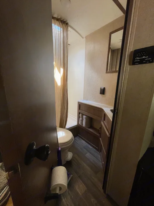 RV rental bathroom, with toilet, shower curtain, and vanity. Features compact design for road trips.. Starcraft Autumn Ridge 2018