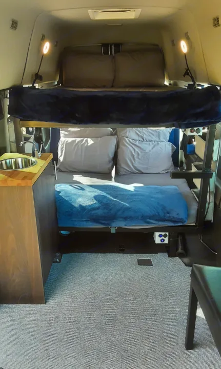 This RV rental features comfortable bunk beds and a compact kitchenette with a sink, perfect for camper travel.. Ford transit 2017