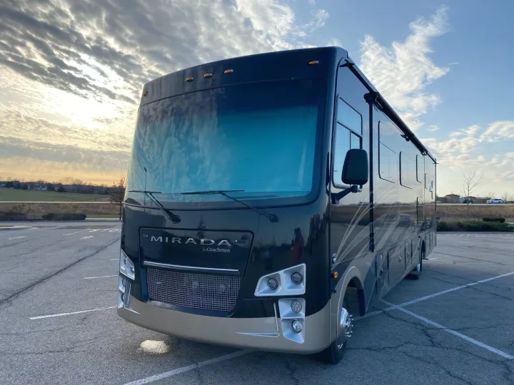 Experience travel freedom! This spacious Mirada by Coachmen motorhome, ideal for an rv rental, is parked on asphalt at dusk.. Forest River Coachmen Mirada 2022