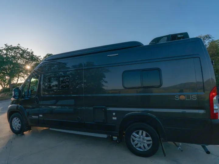 This sleek dark grey Winnebago Solis camper van rv rental is parked at sunset, ready for your next outdoor journey.. Winnebago Solis 59PX 2023