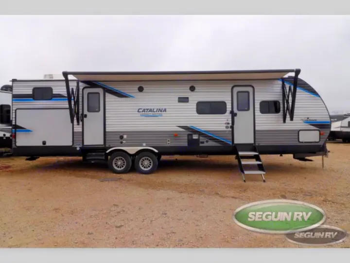 Light gray travel trailer with blue graphics and extended awning, featuring multiple doors, great for rv rental.. Coachmen Catalina 2022