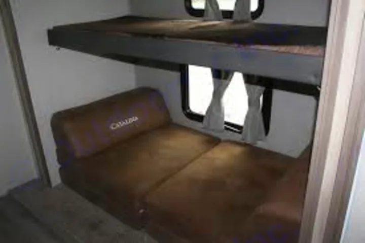 RV rental: Bunk beds. The top bunk is above a brown convertible sofa, providing versatile sleeping options in this RV interior.. Coachmen Catalina 2022