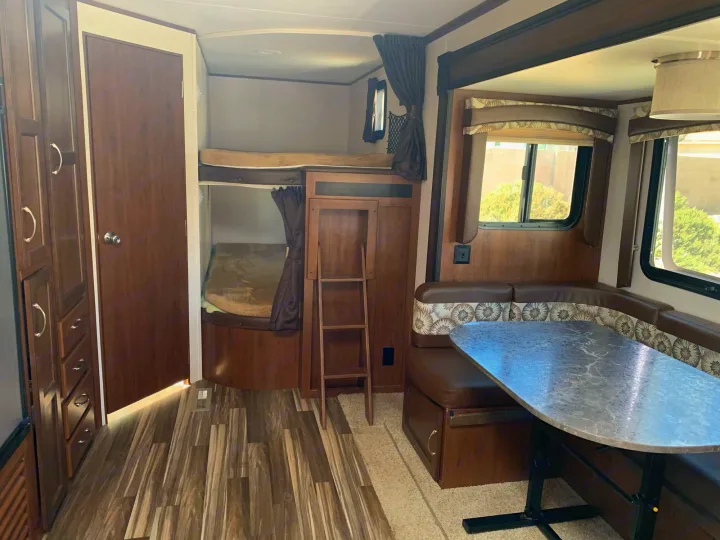 Interior of an RV rental: features include cozy bunk beds, a spacious dinette, and ample storage, perfect for family adventures.. Jayco Jay Flight 2017