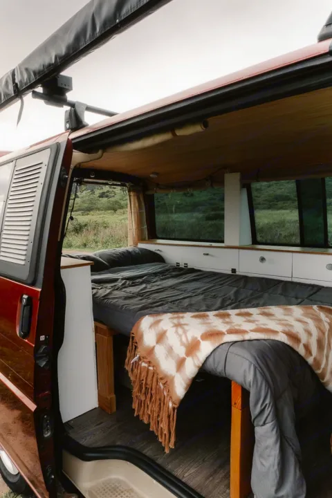 Cozy camper van interior with bed, custom storage, & scenic views. Ideal for your next rv rental adventure or van life journey.. Volkswagen Eurovan 2003