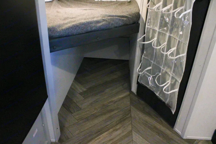 This RV rental features a cozy bunk bed with under-bed space, a clear hanging organizer, and stylish herringbone flooring.. Forest River Salem FSX 2021