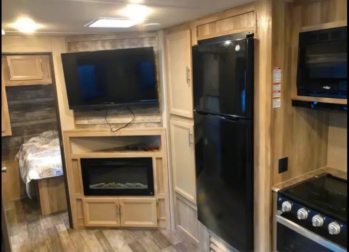 Relaxing fireplace with three different color settings. The TV  w/radio on and outside hookup allows for satellite depending on site accommodations.. Coachmen 263bhsck 2021