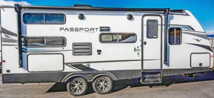 Discover this white Keystone Passport travel trailer, ideal for your next rv rental adventure. Features multiple windows, awning, dual axles.. Keystone RV Passport SL 2021