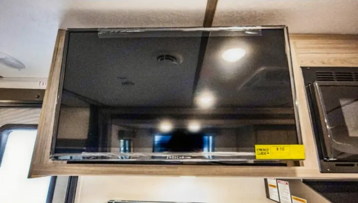 RV rental interior: a mounted PROSCAN TV and microwave, ready for entertainment on your journey.. Keystone RV Passport SL 2021