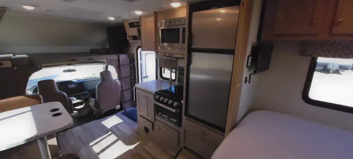 Tour this spacious RV rental interior: fully equipped kitchen, overhead bunk, dining, and comfy bed area.. Forest River Sunseeker 2020