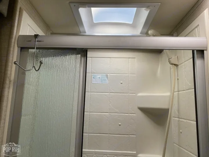 This RV rental features a practical shower stall with a textured glass door, handheld showerhead, and overhead vent.. Jayco Melbourne 2016