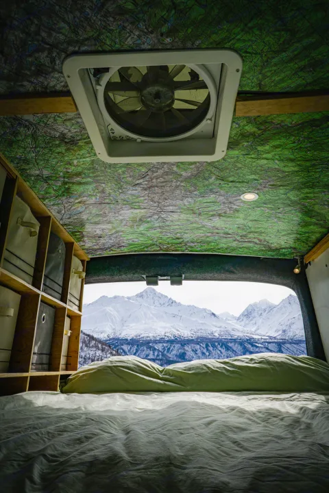 Wake up to stunning views! This rv rental offers a cozy bed, map ceiling, storage, & a vent with snowy mountain vistas.. Ford Transit Custom 2015